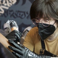 a woman is getting tattooed on her arm