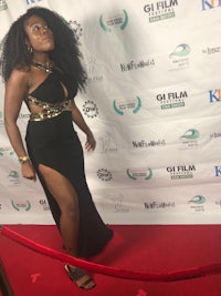 a woman in a black dress posing on a red carpet