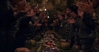 a group of people clapping in front of a long table
