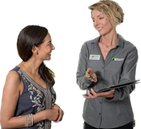 a woman talking to a woman in a grey shirt