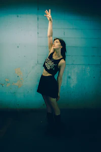 a woman is posing in front of a blue wall