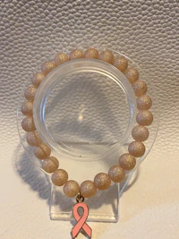 a bracelet with a pink ribbon on it