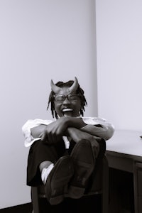 a man sitting in a chair with horns on his head