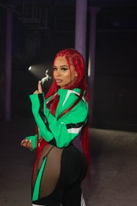 a woman with red hair in a green and black outfit