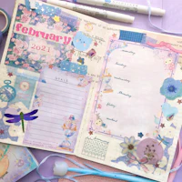 a notebook with pens, pencils and stickers on it