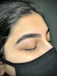 a woman wearing a black mask with her eyes closed