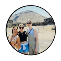 three women posing for a picture in front of a pyramid