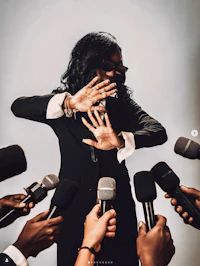 a woman in a suit is surrounded by microphones