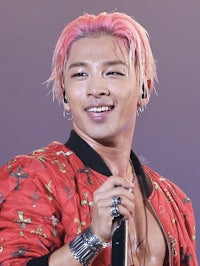 a man with pink hair holding a microphone