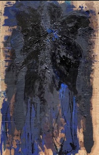 a painting with blue and black paint on a wooden surface
