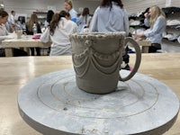 a ceramic mug sitting on a table in a classroom