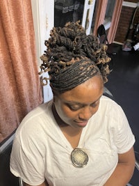 a woman with dreadlocks sitting in a chair