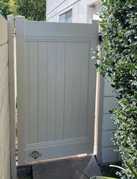 a white wooden gate in a backyard