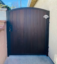 a black wooden gate in front of a house