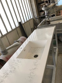 a white sink is being made in a factory