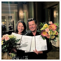 a man and woman holding a bouquet of flowers