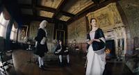 a woman in a period costume is standing in a room