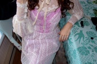 a woman in a lace dress is posing for a picture