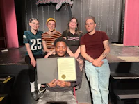 a group of people posing with a certificate
