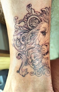 a tattoo of a lion on a person's foot