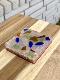 a sea glass coaster sitting on top of a wooden table
