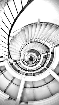 a black and white photo of a spiral staircase