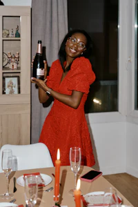 a woman in a red dress holding a bottle of champagne