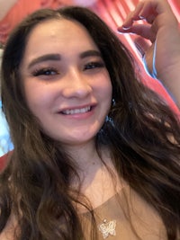 a young woman with long hair smiling for the camera