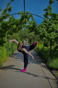 a woman is doing a dance in a park