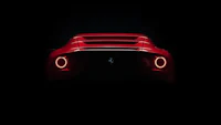 the rear end of a red sports car in the dark