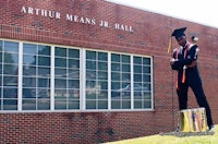 a man standing in front of a building with a drum