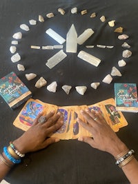 a person holding a tarot card in front of a circle of stones