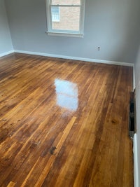 an empty room with wood floors and a window