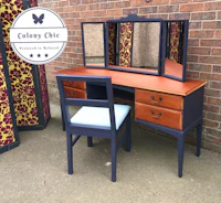 a dressing table with a mirror and a chair