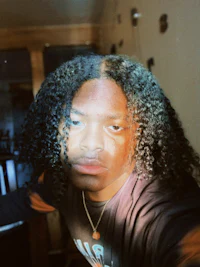 a man with curly hair in front of a mirror
