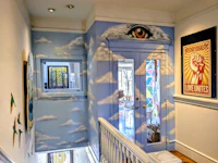 a hallway with a painting of an eye and clouds