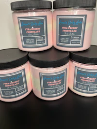 four pink jars of body butter on a table