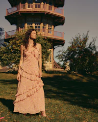 a woman in a pink dress standing in front of a pagoda