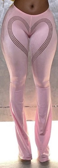 a woman in pink leggings posing in front of a wall