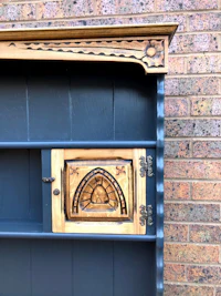 a black hutch with an ornate door