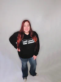 a woman wearing a black hoodie and jeans