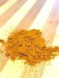 a pile of yellow powder on a wooden table