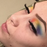 a woman with rainbow colored makeup on her face