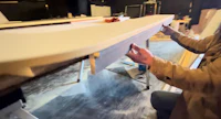 a man working on a surfboard in a workshop