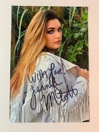 an autographed photo of a woman in a white jacket