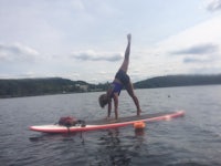 a woman doing a yoga pose on a surfboard