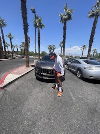 a person standing next to a car in a parking lot
