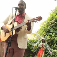 a man is playing an acoustic guitar in front of a statue