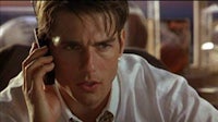 a man talking on a cell phone in a white shirt