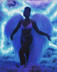 a woman in a bikini standing in the clouds with angel wings